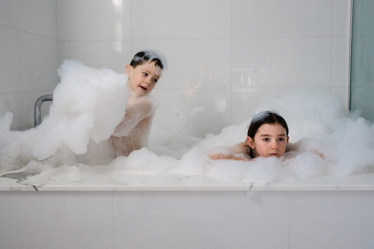 brother collecting bubbles in the bath